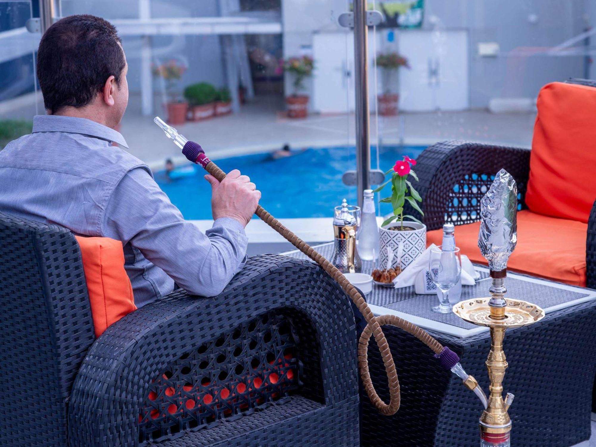 Novotel Jazan Extérieur photo A man smoking a hookah