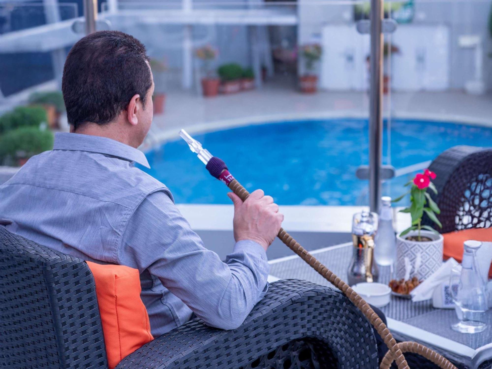 Novotel Jazan Extérieur photo A man smoking a hookah
